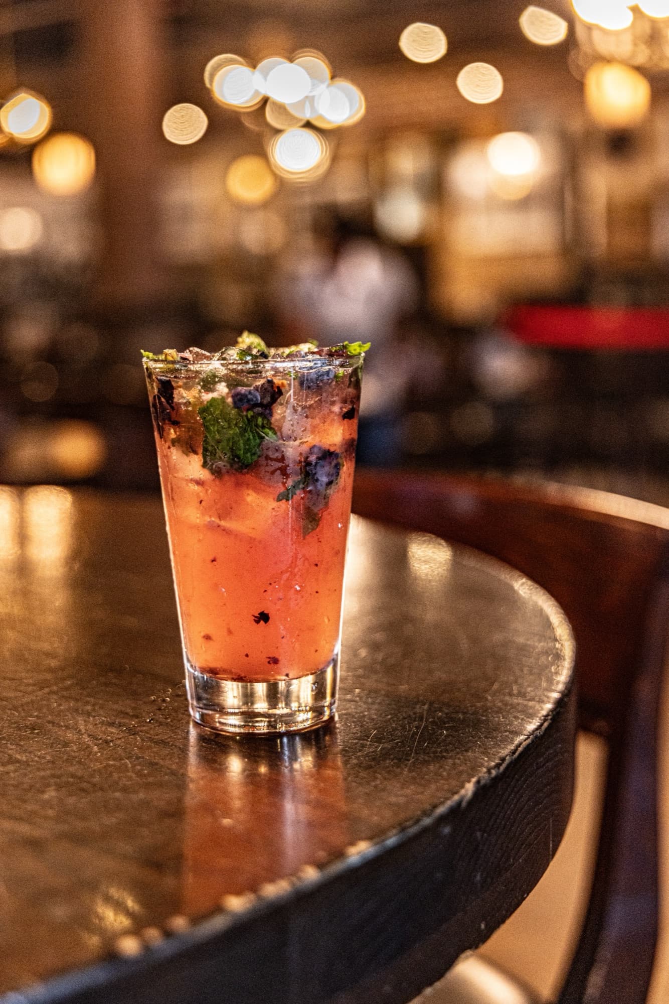 A hand-crafted cocktail against warm bar lights